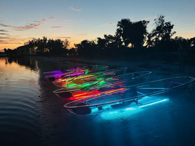 see through kayaks with neon lights on the beach at kool kayak ami
