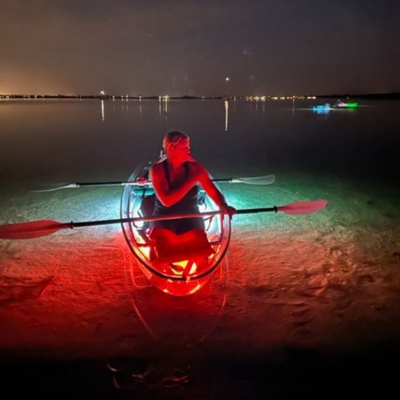 people kayaking at night in see through kayaks with neon lights 3