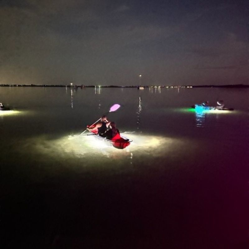 people kayaking at night in see through kayaks with neon lights 4