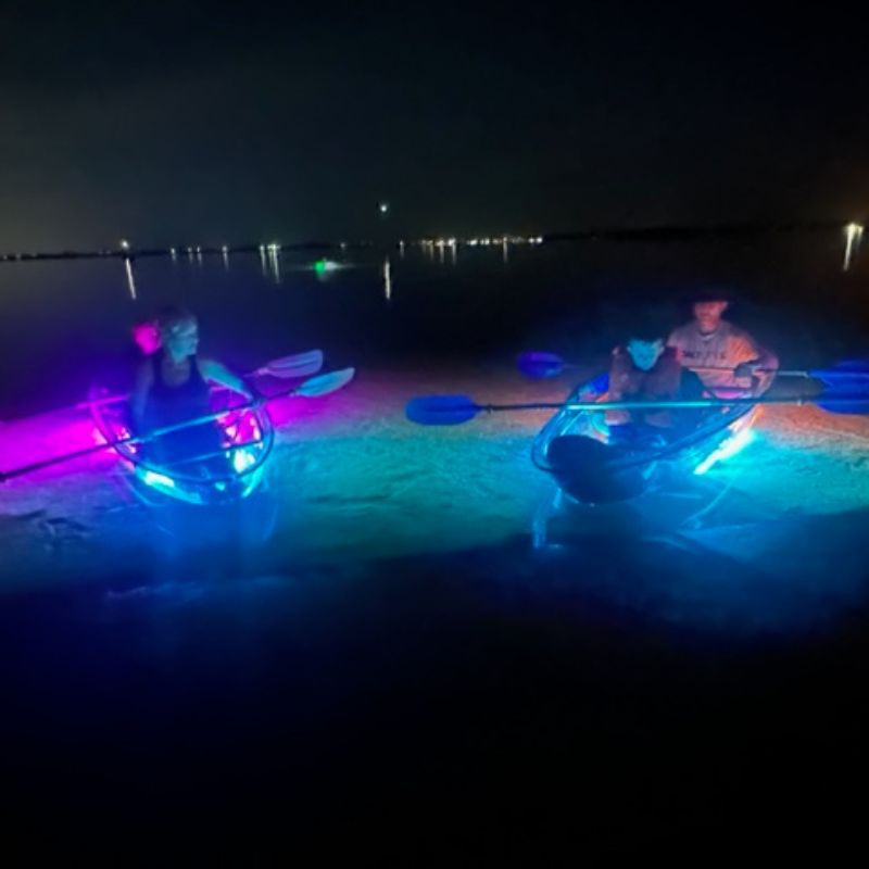 people kayaking at night in see through kayaks with neon lights 1